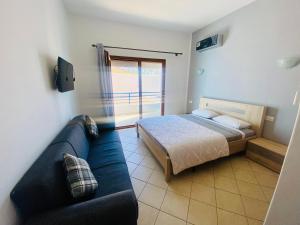 ein Schlafzimmer mit einem Bett und einem blauen Sofa in der Unterkunft Cabo Dream Apparthotel in Cabo Negro