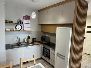 eine Küche mit weißen Schränken und einem weißen Kühlschrank in der Unterkunft Apartament Wacyn Idea in Radom
