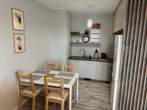 eine Küche und ein Esszimmer mit einem Tisch und Stühlen in der Unterkunft Apartament Wacyn Idea in Radom
