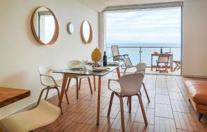 ein Esszimmer mit einem Tisch und Stühlen sowie Meerblick in der Unterkunft Awesome Apartment In Giardini Naxos With Wifi in Giardini-Naxos