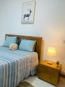 a bedroom with a bed with a lamp and a deer on the wall at SuAparts in Praia