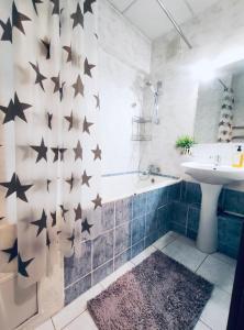 een badkamer met zwarte sterren op de muur bij Like Home Guest Rooms in Alma-Ata
