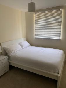 a white bed in a room with a window at 1 bed Flat Service Apartment Beckenham with Free Parking in Beckenham