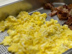 a metal container filled with scrambled eggs and bacon at Hotel Morolli in Rimini