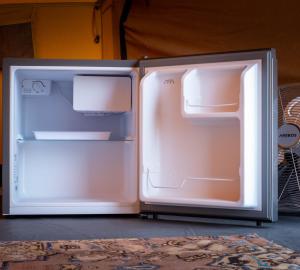an open refrigerator is sitting on the floor at Glamping Camp Faro in Faro