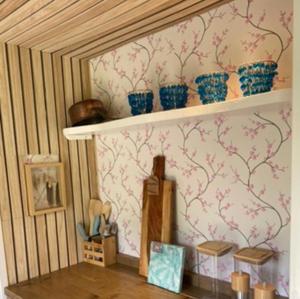 a shelf with blue and pink flowers on a wall at Caravan Stadstuin Goedereede let op de badkamer moet met andere gasten gedeeld worden in Goedereede