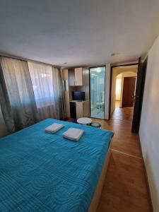 een slaapkamer met een blauw bed met 2 handdoeken erop bij Casa Maria Busteni - Poiana Tapului in Buşteni