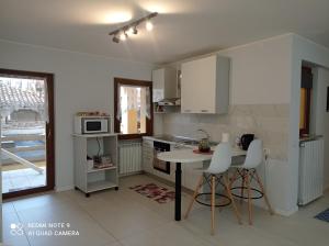 a kitchen with a table and some chairs in a room at Sweet Home in Tolmezzo