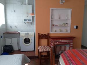 uma cozinha com uma máquina de lavar roupa e uma lareira em Mi Rincón bonito em Salta