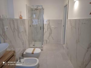 een badkamer met een douche, een toilet en een wastafel bij Sweet Home in Tolmezzo