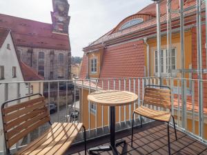 un balcón con 2 sillas y una mesa en el balcón en Alte Bäckerei Königstein Aparthotel und Café en Königstein an der Elbe
