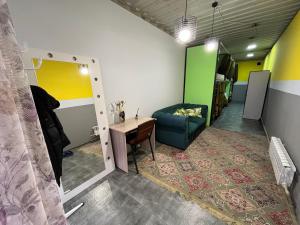 a room with a couch and a table and a chair at Fox Fort Hostel in Almaty