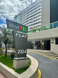 una señal frente a un edificio alto en Via Venetto Flat en Fortaleza