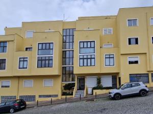 a yellow building with cars parked in front of it at Apartamento Solaris T1 - Férias Albufeira in Albufeira +3 photos