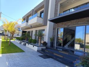 uma casa moderna com plantas em frente em Oikos 9 Rooms and Suites em Lepanto