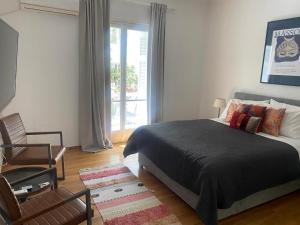 sypialnia z łóżkiem, krzesłem i oknem w obiekcie Cutie by Stylish Stays w Atenach