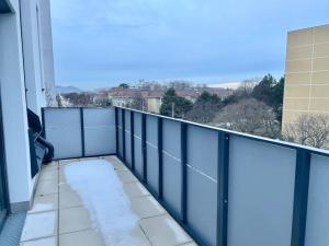 einen Balkon mit Schnee auf der Etage eines Gebäudes in der Unterkunft Modern Rooftop Apartment with Free Parking in Wien