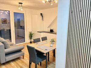 ein Esszimmer und ein Wohnzimmer mit einem Tisch und einem Sofa in der Unterkunft Modern Rooftop Apartment with Free Parking in Wien