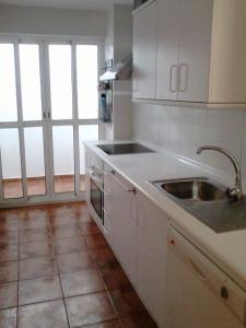 a kitchen with white cabinets and a sink at Casa Tartessos in Costa Ballena +23 photos