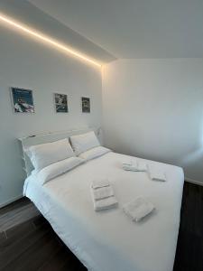een wit bed met twee handdoeken erop bij Lake Home Apartments in Lipomo