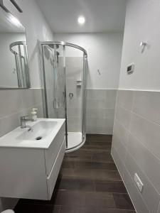 a white bathroom with a shower and a sink at Lake Home Apartments in Lipomo +13 photos