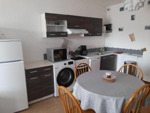 cocina con mesa y nevera blanca en Vacances Xonrupt-Gerardmer, en Xonrupt-Longemer