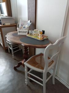 - une table avec un plateau de nourriture et 2 chaises dans l'établissement Chambre dans le centre historique, à Pont-Audemer