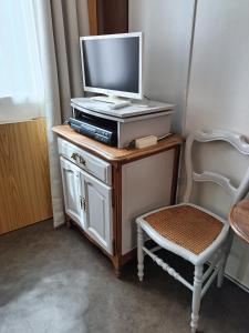 - une télévision assise au-dessus d'une table avec une chaise dans l'établissement Chambre dans le centre historique, à Pont-Audemer