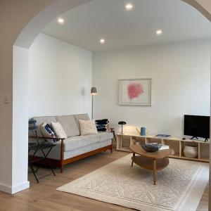 a living room with a couch and a tv at Duplex « Les pieds dans l’eau » in Nernier