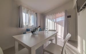 a white table and chairs in a room with a window at Gorgeous Home In Deiva Marina With Wifi in Deiva Marina +12 photos