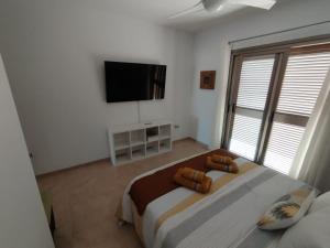 a bedroom with a large bed and a flat screen tv at Villa La Tunera in Costa de Antigua