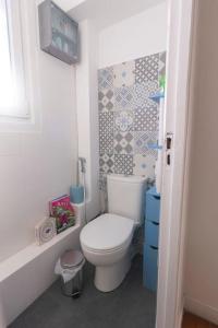 ein Badezimmer mit Toilette und gefliester Wand in der Unterkunft La Maison Du Bonheur PARIS CDG AIRPORT, Bourget, Parcs Astérix,Expos, Disney Land, in Gonesse + 10 Fotos