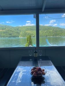 a bowl of fruit on a table with a view of a lake at Splav ANDJELA Perucac in Perućac