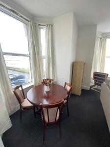 a dining room with a table and chairs and windows at Farina No4, Sea view apartment sleeping 4 guests in Bridlington +2 photos