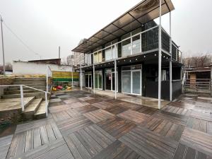 a building with a wooden deck with a building at Fox Fort Hostel in Almaty