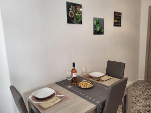 tavolo da pranzo con bottiglia di vino e bicchieri di Garibaldi Square Central City a Bari