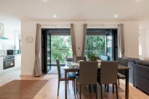 a dining room and living room with a table and chairs at Modern Comfort Two Bedrooms Flat, Coulsdon CR5 in Coulsdon
