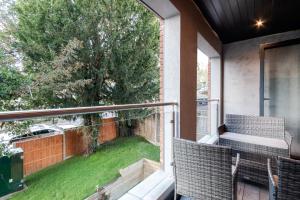 a balcony with two chairs and a view of a yard at Modern Comfort Two Bedrooms Flat, Coulsdon CR5 in Coulsdon