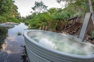 a bath tub in the middle of a river at The Fernery Lodge & Spa in Stormsrivier