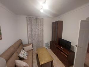 a living room with a couch and a flat screen tv at CASA JARO in Sierra de Yeguas