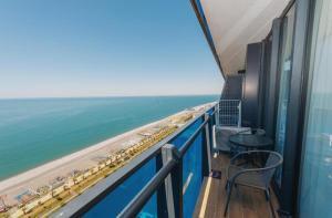 a balcony with a view of the beach and the ocean at Holiday in orbi city in Batumi