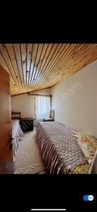 a bedroom with a large bed with a wooden ceiling at Sıcak Cermik Termal Havuzlu Family Villa 1 in Sivas