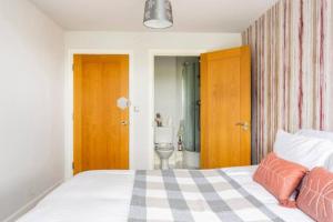 倫敦的住宿－Lovely en-suite double room，一间卧室配有一张床,浴室设有卫生间
