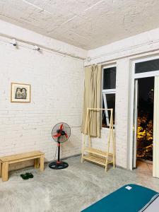 a room with a fan a table and a window at May’s house Nhà của Mây in Hanoi