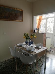 a dining room table with a vase of flowers on it at Sunday's Apartment in Preveza