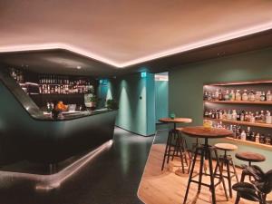 un bar con taburetes y mesas en una habitación en Hotel Al Caminetto WorldHotels Crafted Adults Only, en Torri del Benaco
