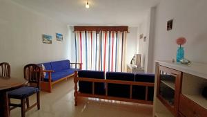 sala de estar con sofá azul y mesa en alquilaencanarias Tio Claudio Beach en El Médano