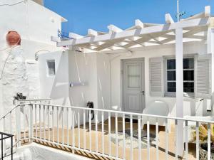 a white house with a balcony with a door at Cabarnus House in Parikia