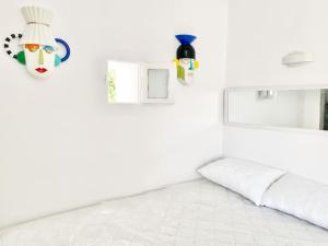 a white room with a bed and a mask on the wall at Cabarnus House in Parikia