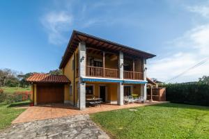 a large yellow house with a balcony at Casa cerca Playa Cuevas del Mar Llanes - River in Llanes